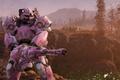 A pink and white robot holding a large gun in the wasteland of Fallout 76.